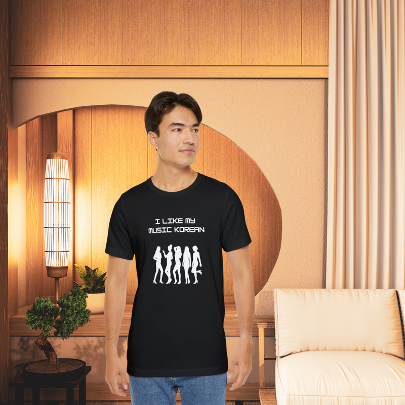 Unisex black graphic T-shirt featuring K-pop silhouettes and bold text ‘I LIKE MY MUSIC KOREAN,’ styled in a serene, modern room with cotton accents and natural lighting.